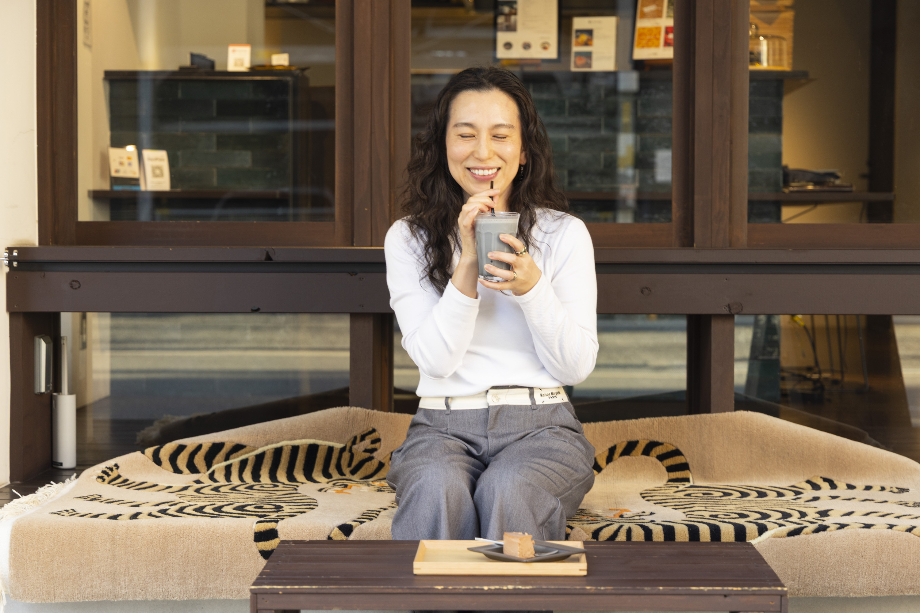 カフェIRUAERUでごまドリンクを楽しみながら笑顔を見せるお客様