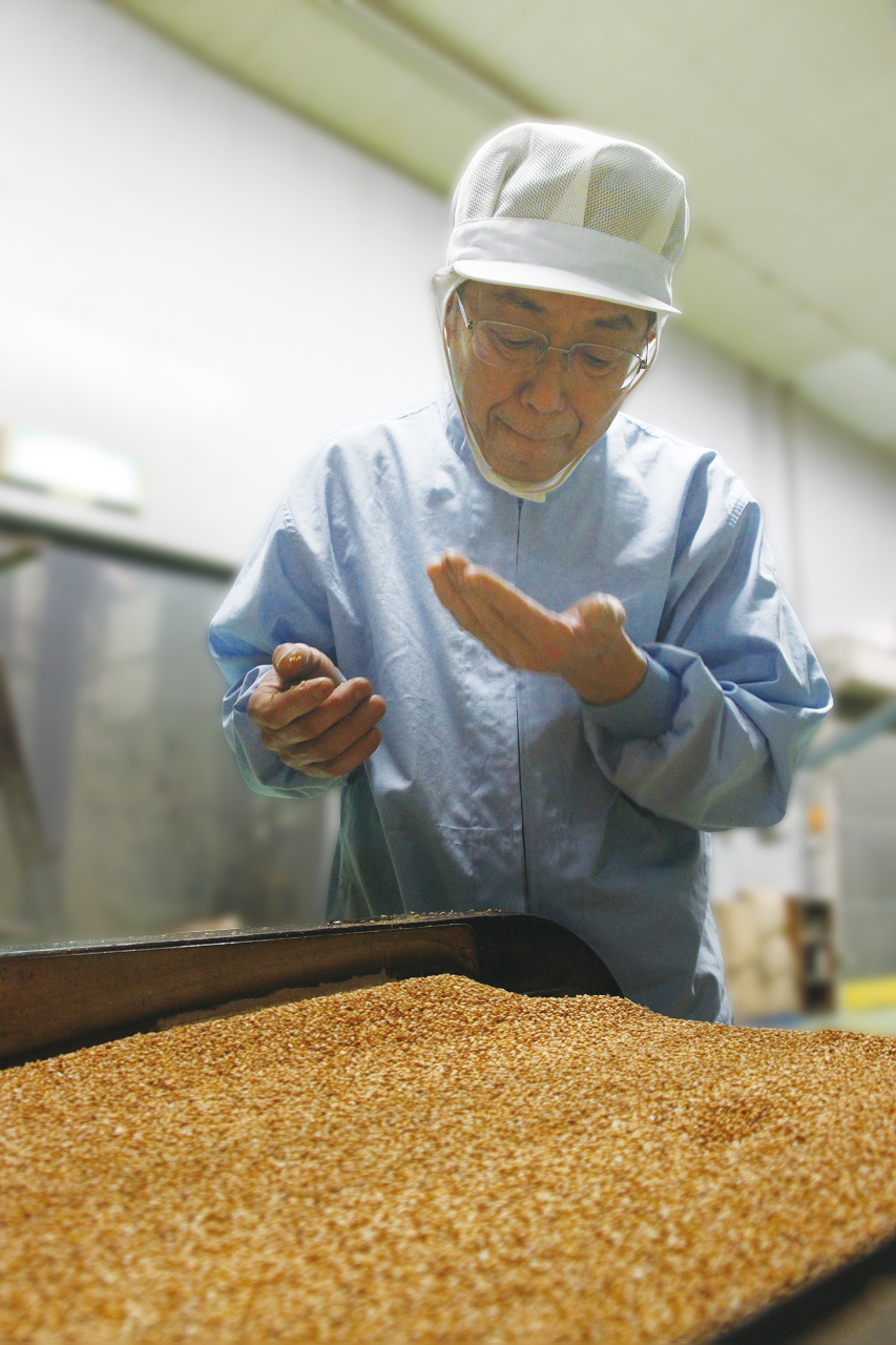 焙煎したごまの仕上がりを手と鼻で確認する和田萬の職人